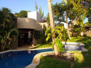 a house with a palm tree next to a swimming pool at Paraiso Tropical - Casa 7 in Pipa