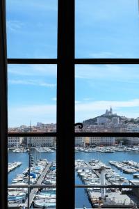 a view from a window of a harbor with boats in the water at Hotel Belle-Vue Vieux-Port in Marseille