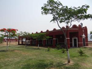 uma casa vermelha com uma árvore em frente em Hacienda Santa Clara, Morelos, Tenango, Jantetelco em Jantetelco