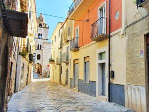 an alley in an old town with a clock tower at CASA MALUDA - Fondi Vertice Rooms in Fondi