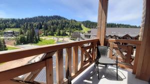 a chair sitting on a balcony with a view at Apartman Lukas privatni app u sklopu aparthotela Vučko in Jahorina