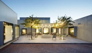 un patio con sillas y mesas frente a un edificio en Hotel Aire de Bardenas, en Tudela
