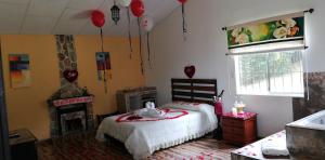 a bedroom with a bed and a fireplace and balloons at Hotel Campestre El Refugio de Balsora in Filandia