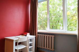 Habitación con mesa, ventana y radiador en Slucko Central Studio Apartment near River en Vilna