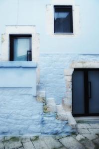 a white building with two doors and two windows at L'ArChasetta Historic Apartments in Casamassima