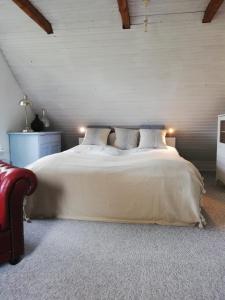 a bedroom with a large white bed with two pillows at Tankefuld Living's Horsefarm in Svendborg