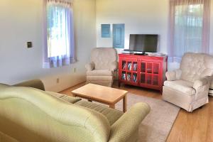uma sala de estar com um sofá e duas cadeiras e uma televisão em Mountain Top Country Hideaway 48 Acres, Fire Pit! em Leonardsville