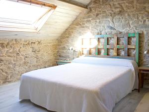 a bedroom with a large bed in a stone wall at Apartamentos Teixoeira in Artes