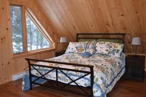 a bedroom with a bed in a cabin at Les Chalets du Lac Serein (Milot) in Saint Ludger de Milot