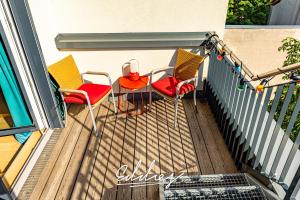 eine Terrasse mit 3 Stühlen und einem Tisch auf dem Balkon in der Unterkunft Eddie’s Design Apartments in Wien