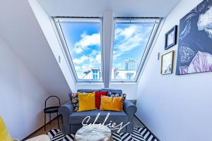 a room with a window and a blue couch with colorful pillows at Eddie’s Design Apartments in Vienna
