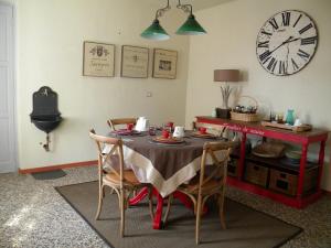 a dining room with a table and a clock on the wall at B&B Autin in Bruzolo