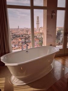 a white bath tub in a room with a window at Relais Colle San Pietro in Verona