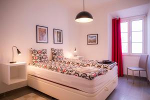 a bedroom with a large bed with red curtains at Apartamentos Marreiros Neto in Lagos