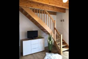 a living room with a tv and a staircase at Domek Polny czar in Pogorzelica