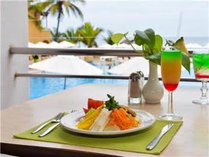 a plate of food on a table with a drink at VILLA PARA 8p 6A 2M dentro del HOTEL a un costado del Krystal IXTAPA cuenta con playa y WIFI in Ixtapa