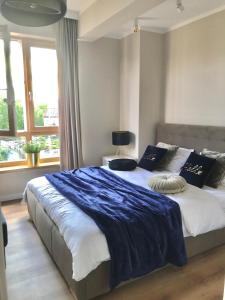 une chambre avec un grand lit avec une couverture bleue dans l'établissement Marina Blue-Apartament przy promenadzie, à Ełk