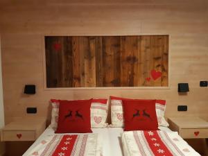 una camera con 2 letti con cuscini rossi di Appartamento Paganella ad Andalo