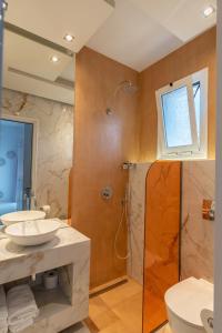 a bathroom with two sinks and a shower and a toilet at Studios Filipidis in Chrysi Ammoudia
