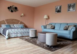 a bedroom with a bed and a blue couch at Neonele in Palanga