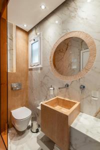 a bathroom with a tub and a toilet and a mirror at Studios Filipidis in Chrysi Ammoudia