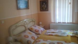 a bedroom with a bed with a headboard and pillows at Apartmány Agi a Milan in Spišská Nová Ves