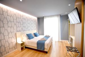 1 dormitorio con 1 cama con almohadas azules en Nina B&B, en Reggio Calabria