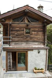 a house with a wooden facade with a window at Le petit chalet in Crépin