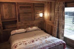 a bedroom with a bed in a room with a window at Le petit chalet in Crépin