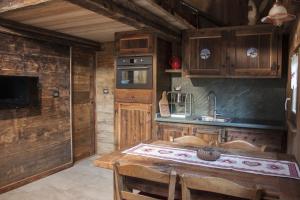 a kitchen with a wooden table and a sink at Le petit chalet in Crépin