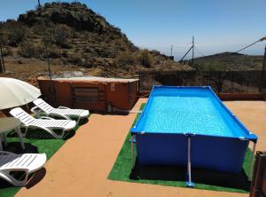 a swimming pool with lounge chairs and a table at Casa Roque in Telde