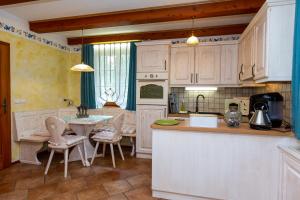 a kitchen with white cabinets and a table and chairs at Apartment Pod Skalco in Jesenice