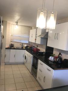 uma cozinha com armários brancos e um balcão preto em Pendleton Valley em Peterborough