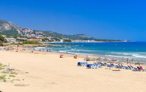 - une plage avec un bouquet de chaises et l'océan dans l'établissement CHALET ADOSADO DULCINEA Alcossebre, à Alcossebre