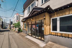 札幌的住宿－Yamahana Onsen Tonden Japanese Inn，城市街道上建筑物前面的商店