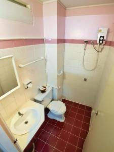 a bathroom with a toilet and a sink at Pacific Inn in Phuket