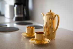 a gold tea kettle and two cups on a counter at Shannon Breeze B&B in Killaloe