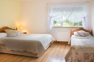 a white bedroom with two beds and a window at Shannon Breeze B&B in Killaloe