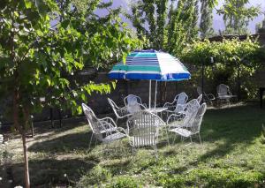 una mesa y sillas bajo una sombrilla en un patio en Rafsal The Guest House, en Tandal