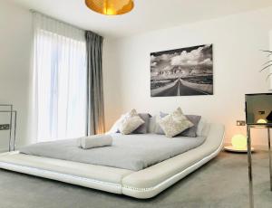 a large white bed in a room with a window at Panoramic Park And City Penthouses Retreat in London