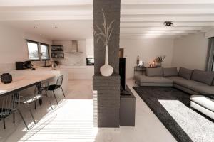 a living room and kitchen with a couch and a table at Villa Arleo in Nieuwpoort