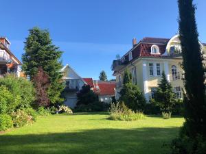 ein großes weißes Haus mit einem Rasenplatz in der Unterkunft Villa Senator-Marstall in Travemünde