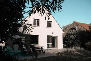 une maison blanche avec une table de pique-nique devant elle dans l'établissement Villa Arleo, à Nieuport