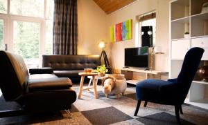 uma sala de estar com um sofá e uma mesa em Buitenverblijf Het Grootenhuis em Winterswijk Henxel