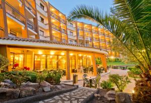 un hotel con un patio con mesas y sillas en GHT Aparthotel Tossa Park, en Tossa de Mar