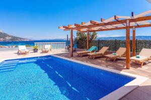 una piscina con pérgola y una villa en Villa Matan - only 200m from the sandy beaches, private 28m2 pool, en Omiš
