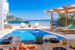 eine Villa mit Swimmingpool und einem Tisch mit Weingläsern in der Unterkunft Villa Matan - only 200m from the sandy beaches, private 28m2 pool in Omiš