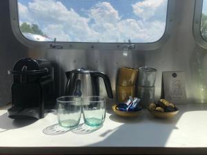 a counter with two glasses and a kettle on it at Amerikaanse Airstream voor 2 personen in Reutum