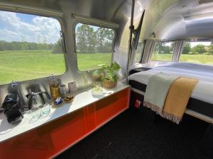 Amerikaanse Airstream voor 2 personen في Reutum: غرفة نوم بسرير ومغسلة في غرفة
