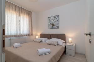 ein Schlafzimmer mit zwei weißen Handtüchern auf einem Bett in der Unterkunft Villa Dalmata in Trogir + 47 Fotos